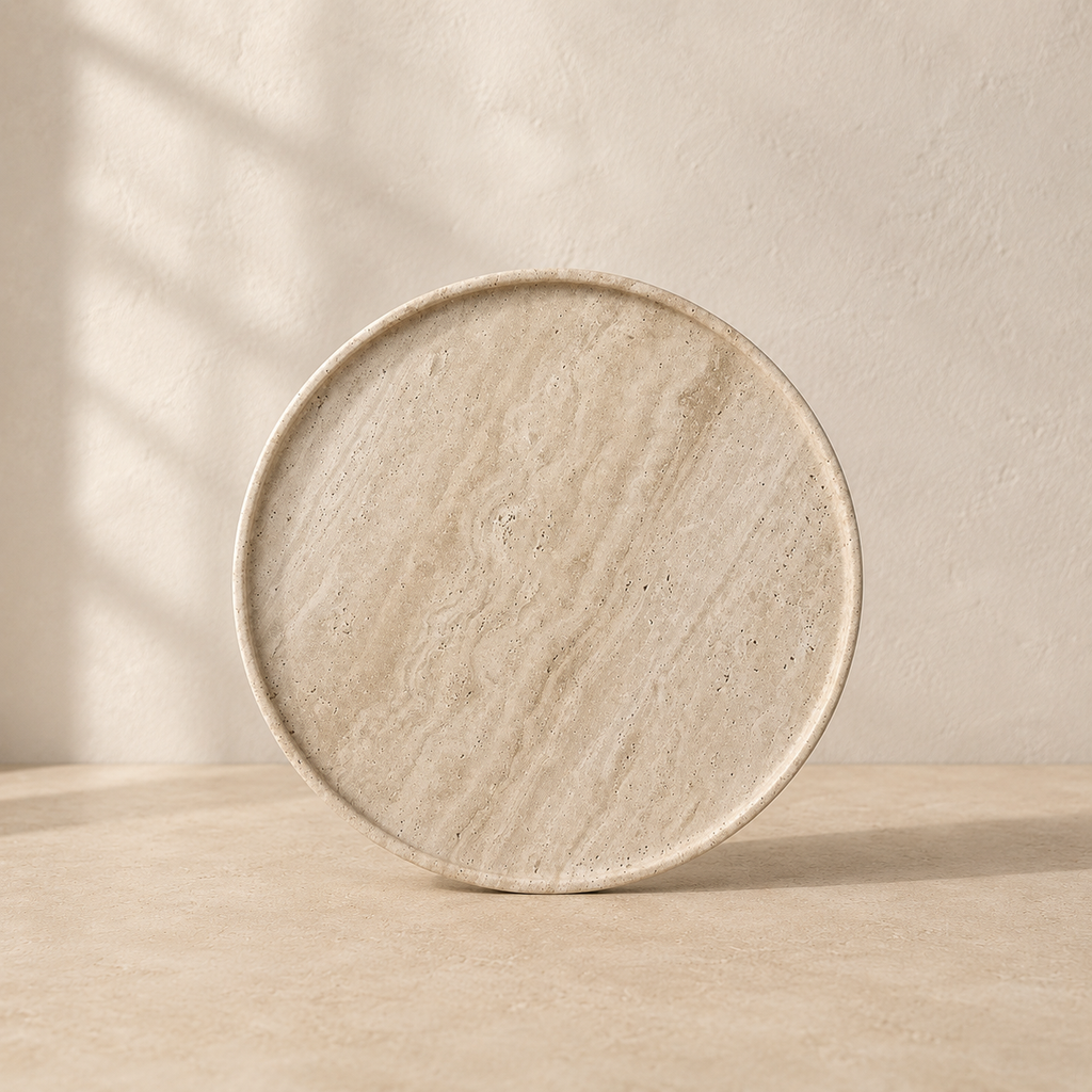The Cornice, a beige travertine plate by Lomāe, twenty-eight centimetres across with open-pore finish