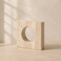 The Oculus, a yellow travertine square with a circular cutout by Lomāe
