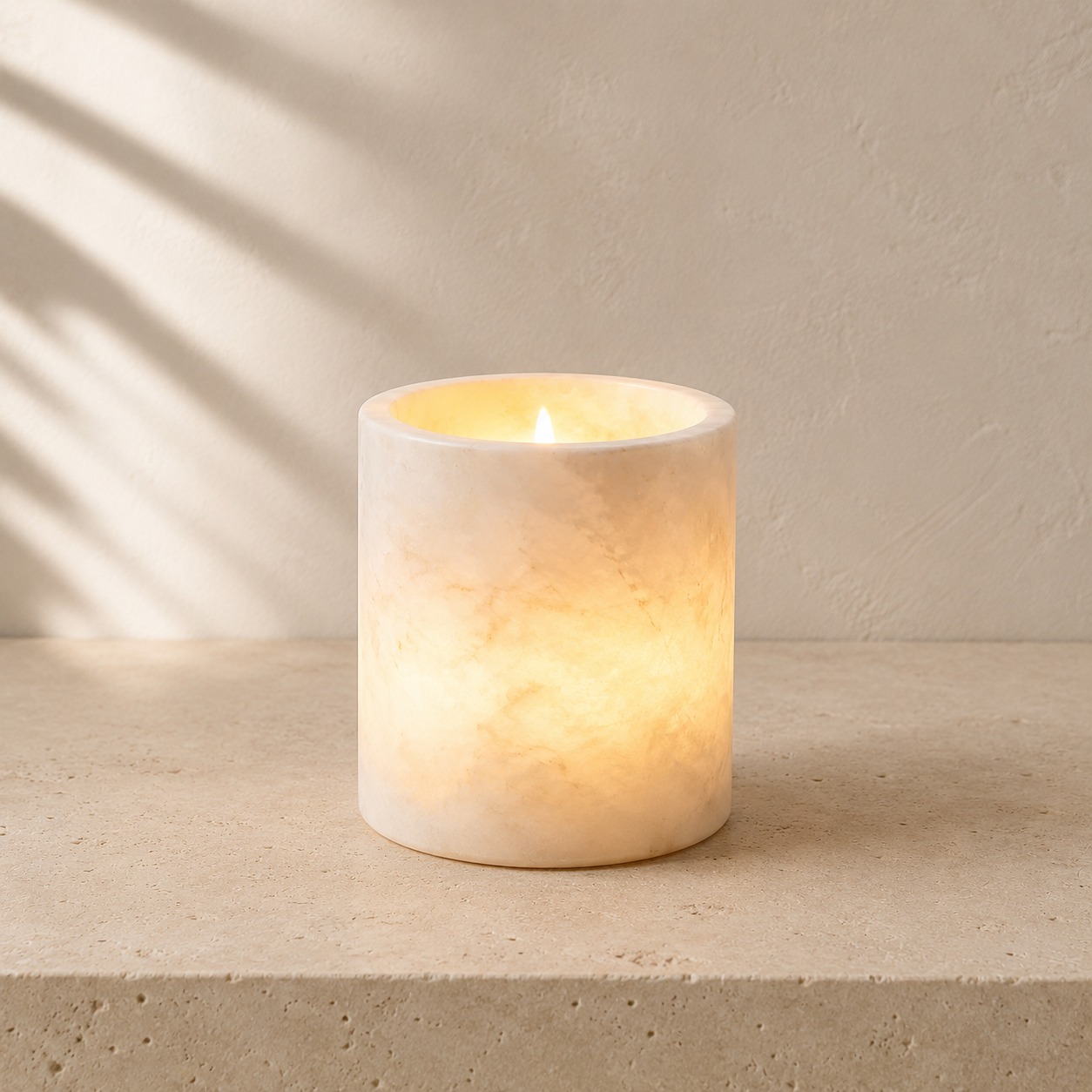 The Vesper, a Spanish alabaster tea light cylinder by Lomāe, glowing softly in low evening light